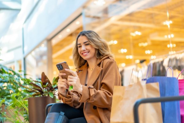 Young,Woman,Smiling,And,Scrolling,On,Her,Smartphone,While,Resting
